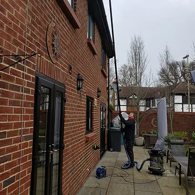 a man is cleaning a sidewalk outside of a building