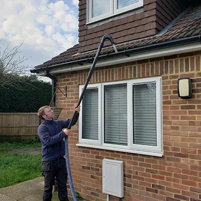a man is using a hose to clean a house