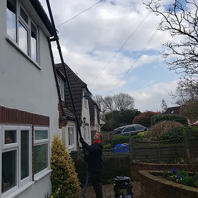 full view of man cleaning front of gutter